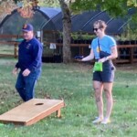 Two participants playing cornhole